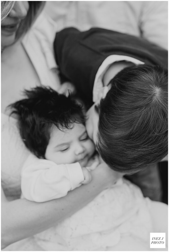 toddler brother kissing baby sister